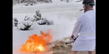 Burri tenton në mënyrë bizare të shkrijë borën nga oborri