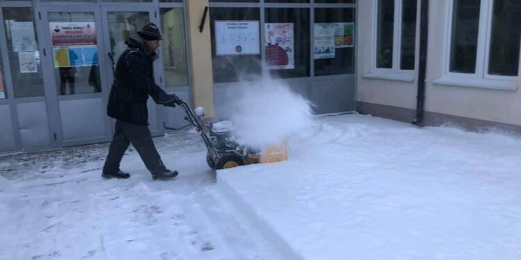 Mërgimtari zgjohet herët dhe heq borën nga oborri i qendrës së votimit